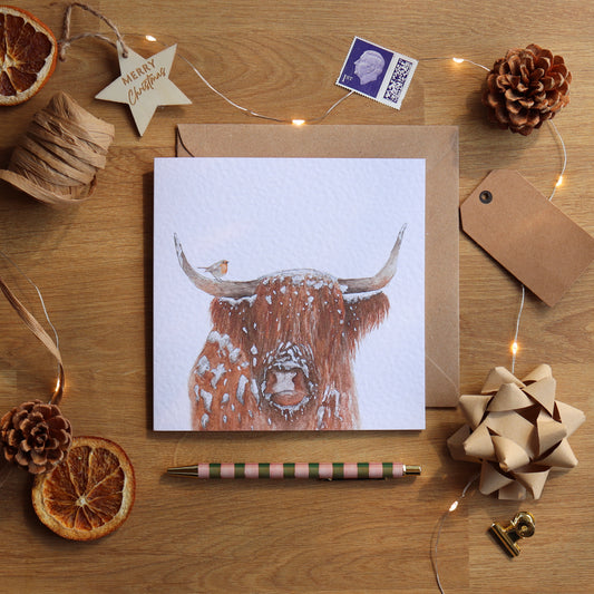 Christmas card with festive highland cow and robin