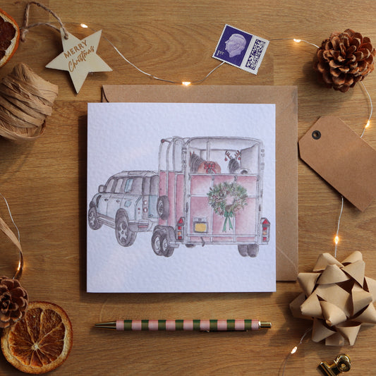 Christmas card with illustration of festive horsebox and defender