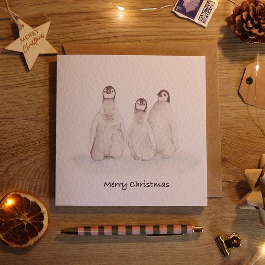 Christmas c and with illustration of 3 penguin babies
