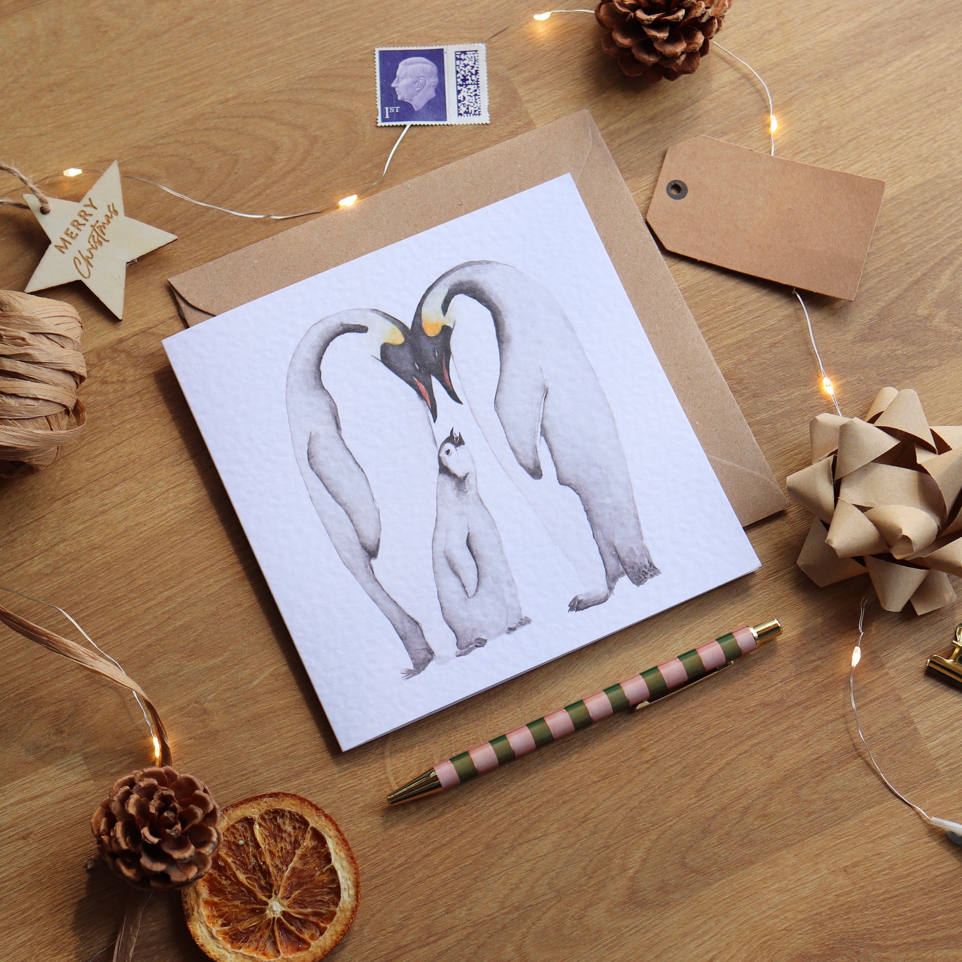 Christmas card with illustration of a family of penguins