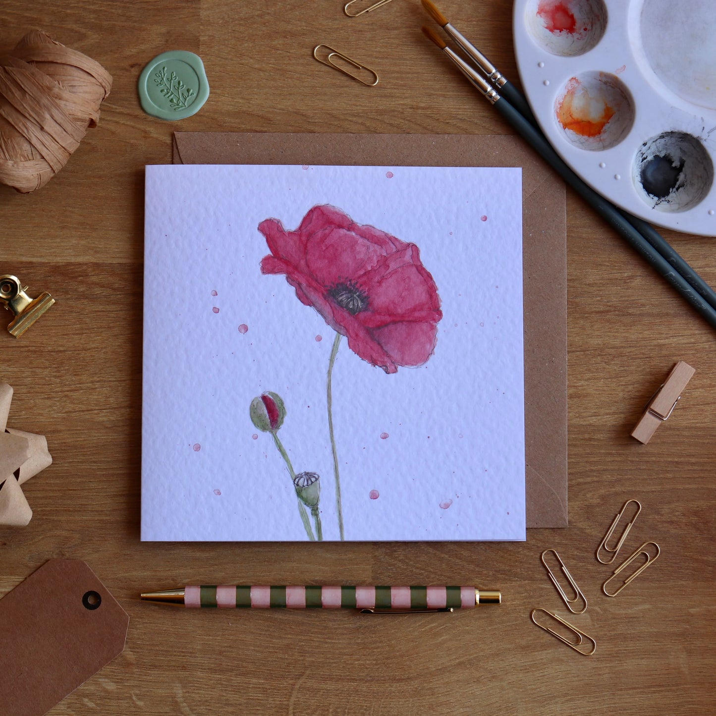 Greeting card with illustration of red poppy and watercolour splashes